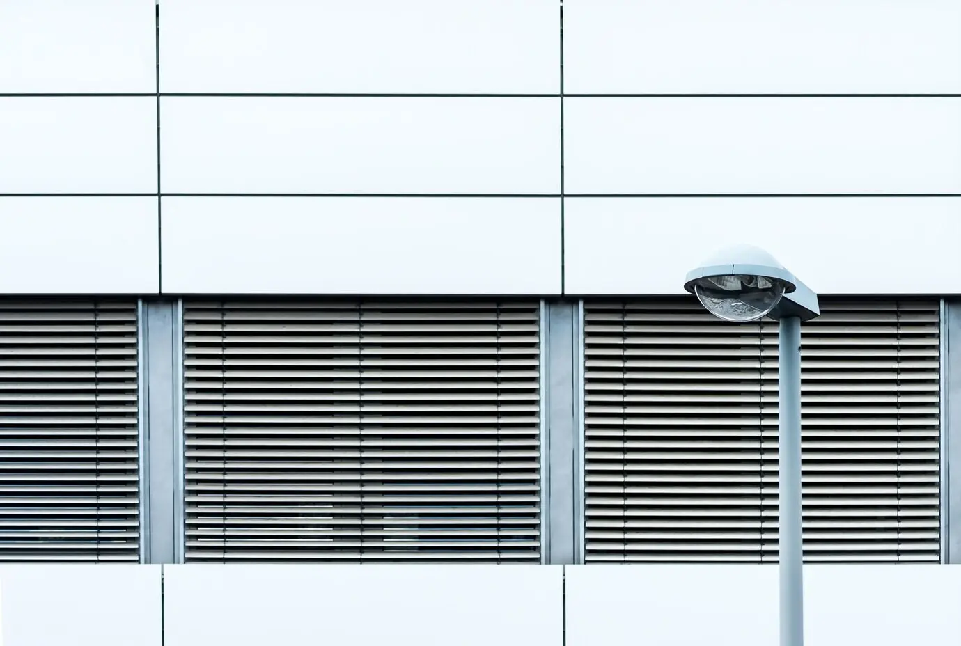 A horizontal shot of a modern building's exterior with shutters, taken outdoors.
